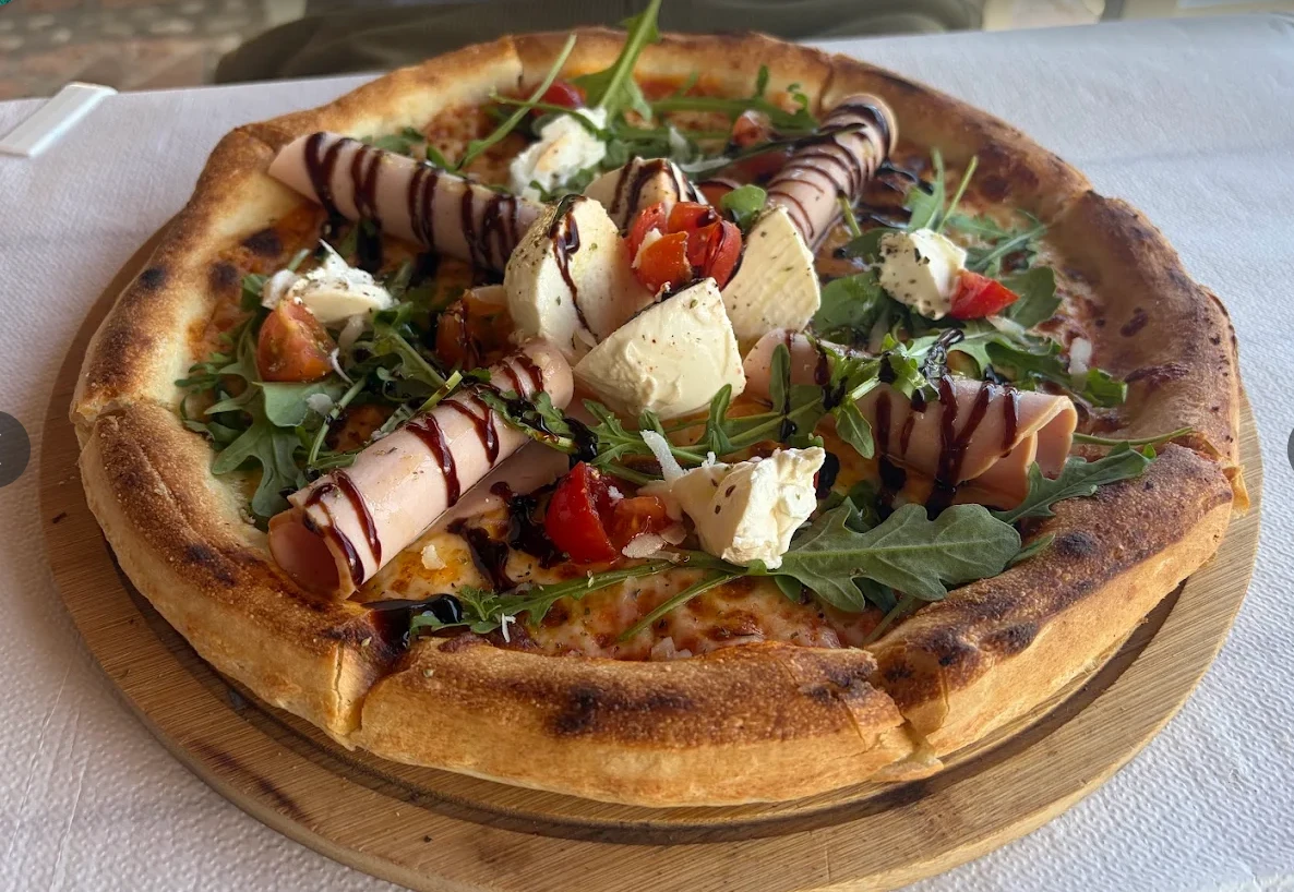 Die Pizza mit Schinkenrollen; ein roter Pfeil markiert den Schinken